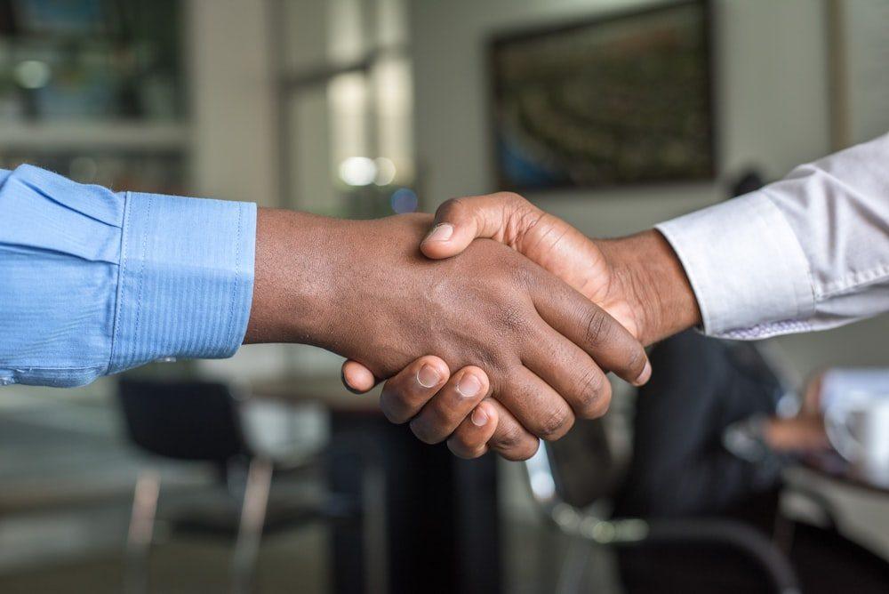 Two people shaking hands after agreeing on a deal